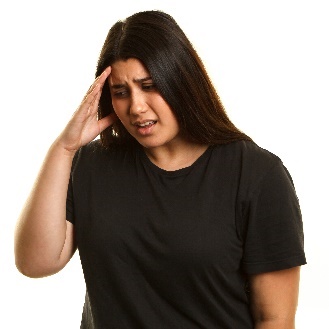 A person holding their head looking worried. 