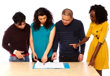 A group of people looking at a document. 