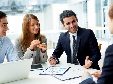 A group of people wearing suits having a meeting.