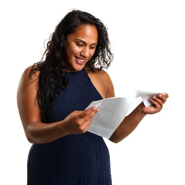 A person smiling, reading a document. 