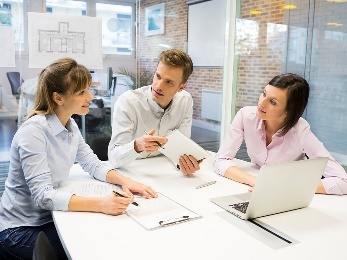 A group of people reading a document together. 