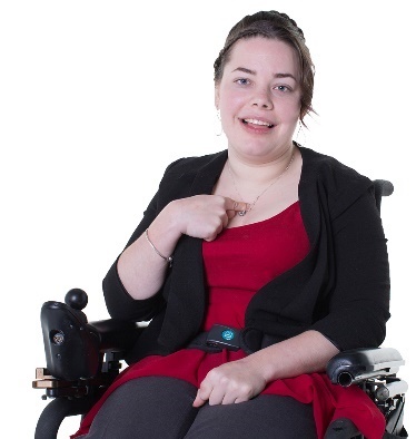 A person in a wheelchair pointing at themselves. 