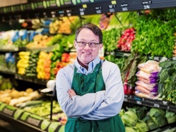 A person at a fruit and vegetable shop. 