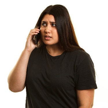  A person looking worried while speaking on the phone. 