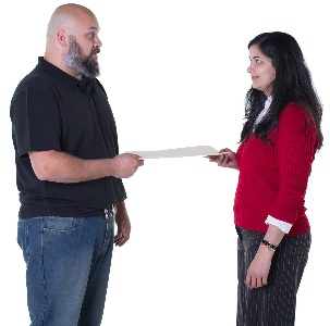 A woman giving a document to a man. 