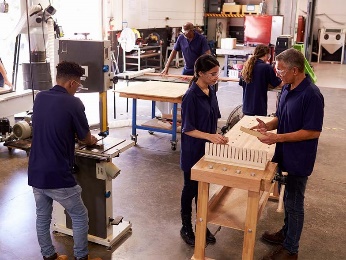 A group of people working in a woodshop. 