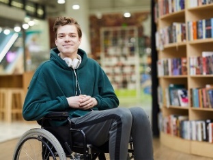 A man in a wheelchair in a university library. 